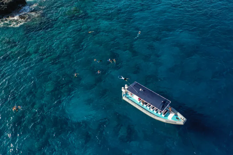 Big Island Snorkeling a boat floating in the bay with snorkelers