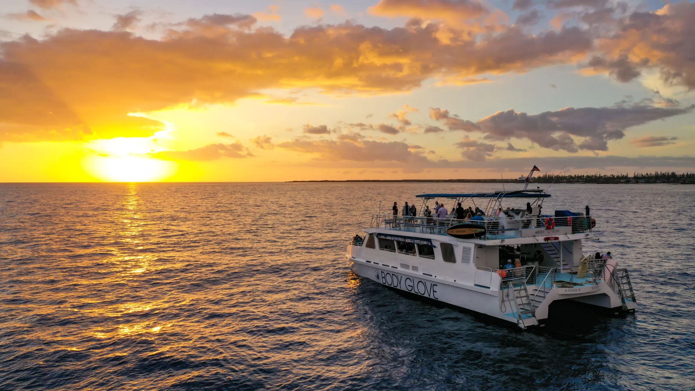 Body Glove catamaran on the water at sunset