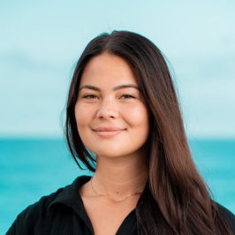 a woman standing in front of a body of water