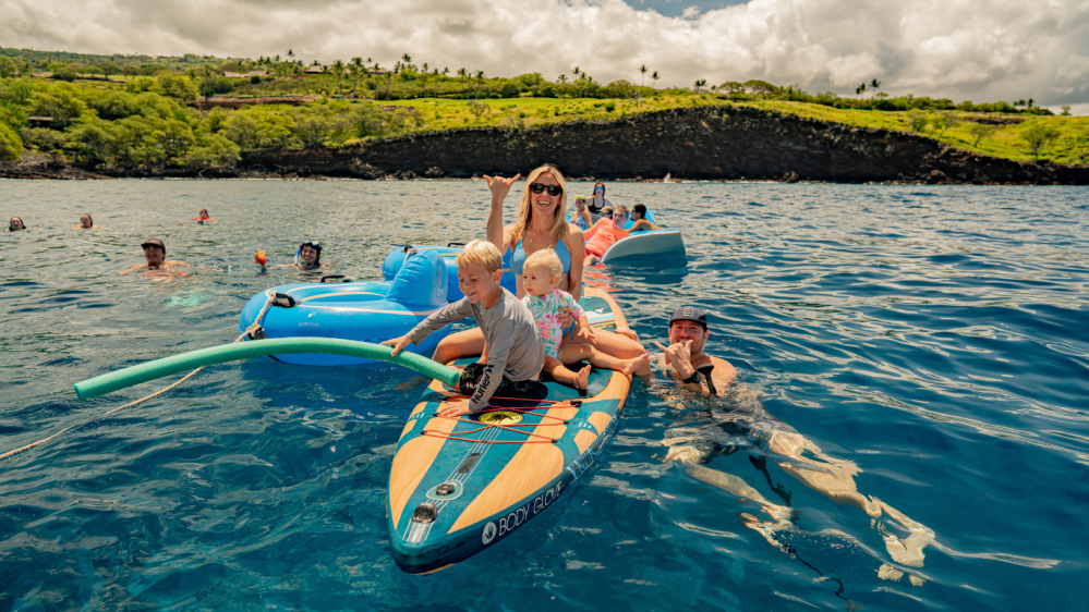 a family swimming in off the coast of kona, hawaii