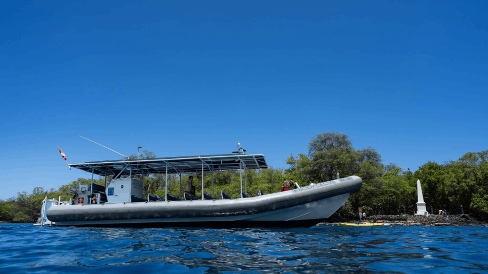 A body glove super raft near the captain cook monument under a clear blue sky in kealakekua bay hawaii