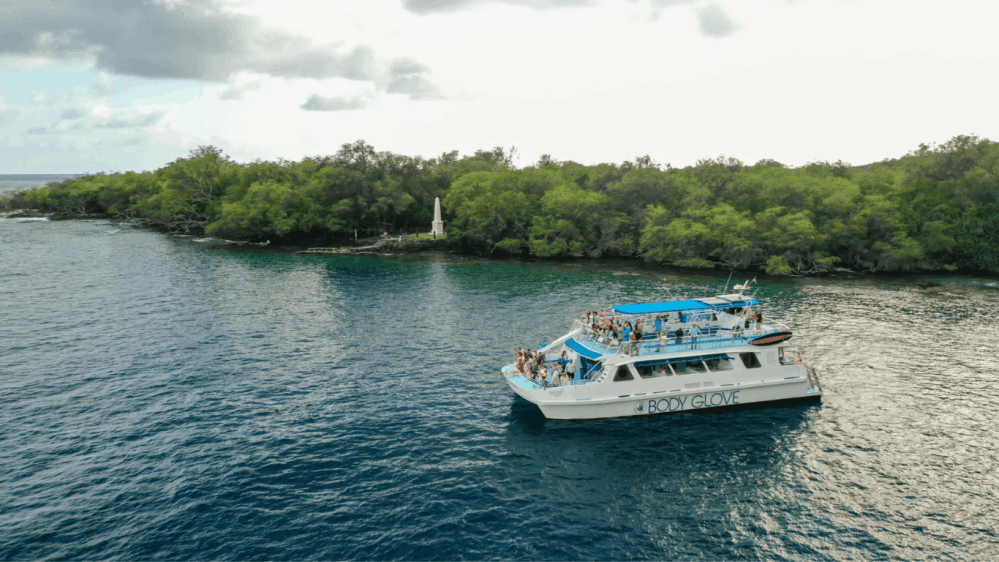 Boat with people near a the captain cook monument in kealakekua bay in hawaii.
